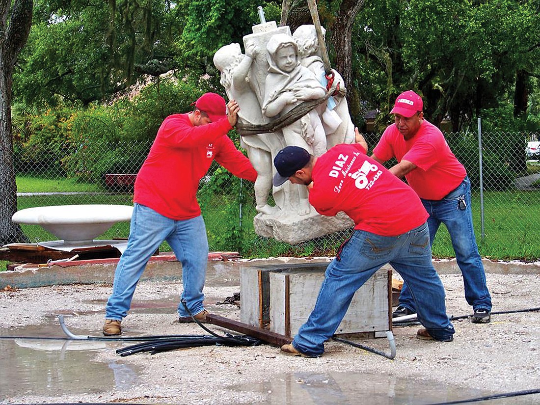 Workers place the duplicate statue onto the fountain.  Courtesy photos