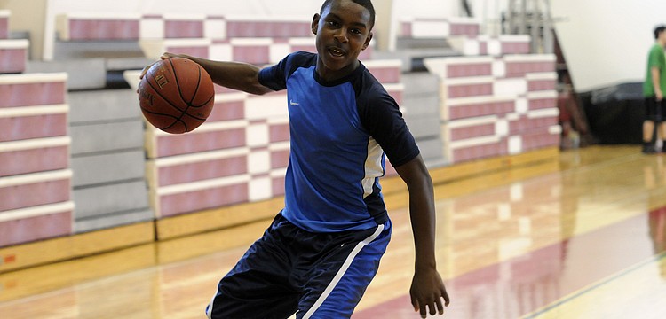 Booker Middle School eighth-grader Deric DuBose dribbles the ball down the lane.