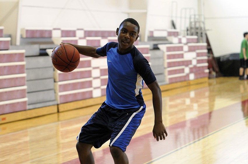 Booker Middle School eighth-grader Deric DuBose dribbles the ball down the lane.