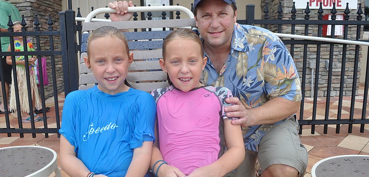 Celia and Faye Swartz, who braved rain to take a swim, with their father, Andy