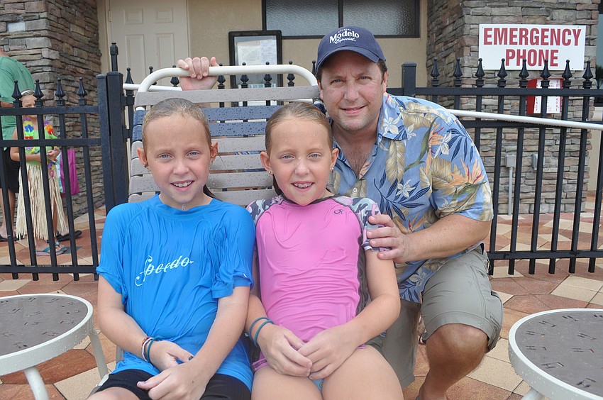 Celia and Faye Swartz, who braved rain to take a swim, with their father, Andy