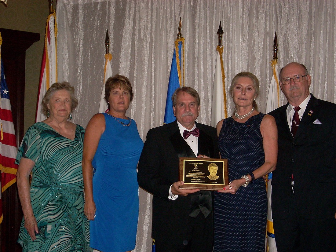 Leslie Hogle accepts the award from FPCA President and Tallahassee Police Chief Dennis Jones, center. (Courtesy FPCA)