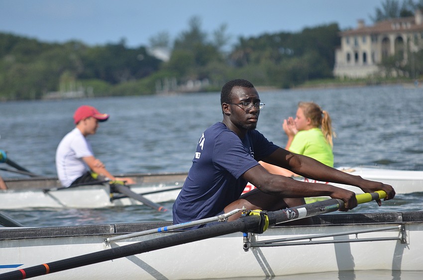 Volunteer Tromaine James helps beginner rowers during the mini regatta.