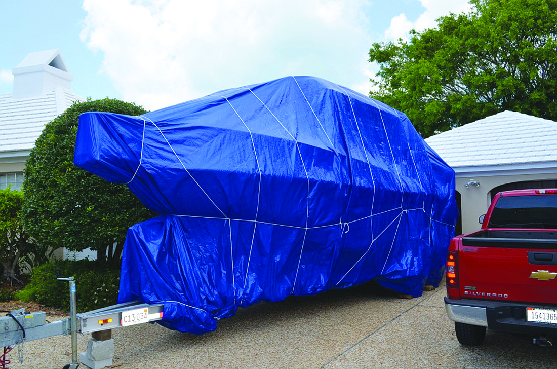 A twin-engine boat of more than 35 feet sitting on a trailer, wrapped in blue tarps, sits in the front of a Bayview Drive home 10 months out of the year. The boat is legal under town code.