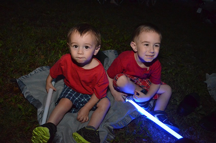 Brothers Silas and London Creech play with light sabers at the fireworks show.