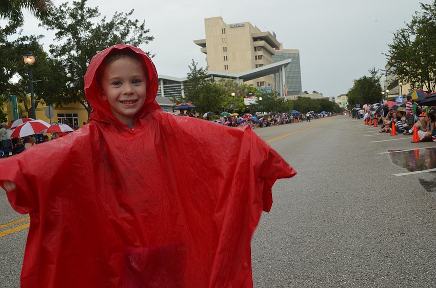 Connor Peterson, 4, stays dry with his poncho raincoat.
