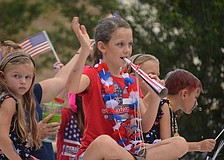 Children wave to the crowd while riding in the parade.