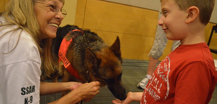 Pat Abrams shows Ayden Shapoiro, 7, how to feed Search & Rescue K-9 Ana.