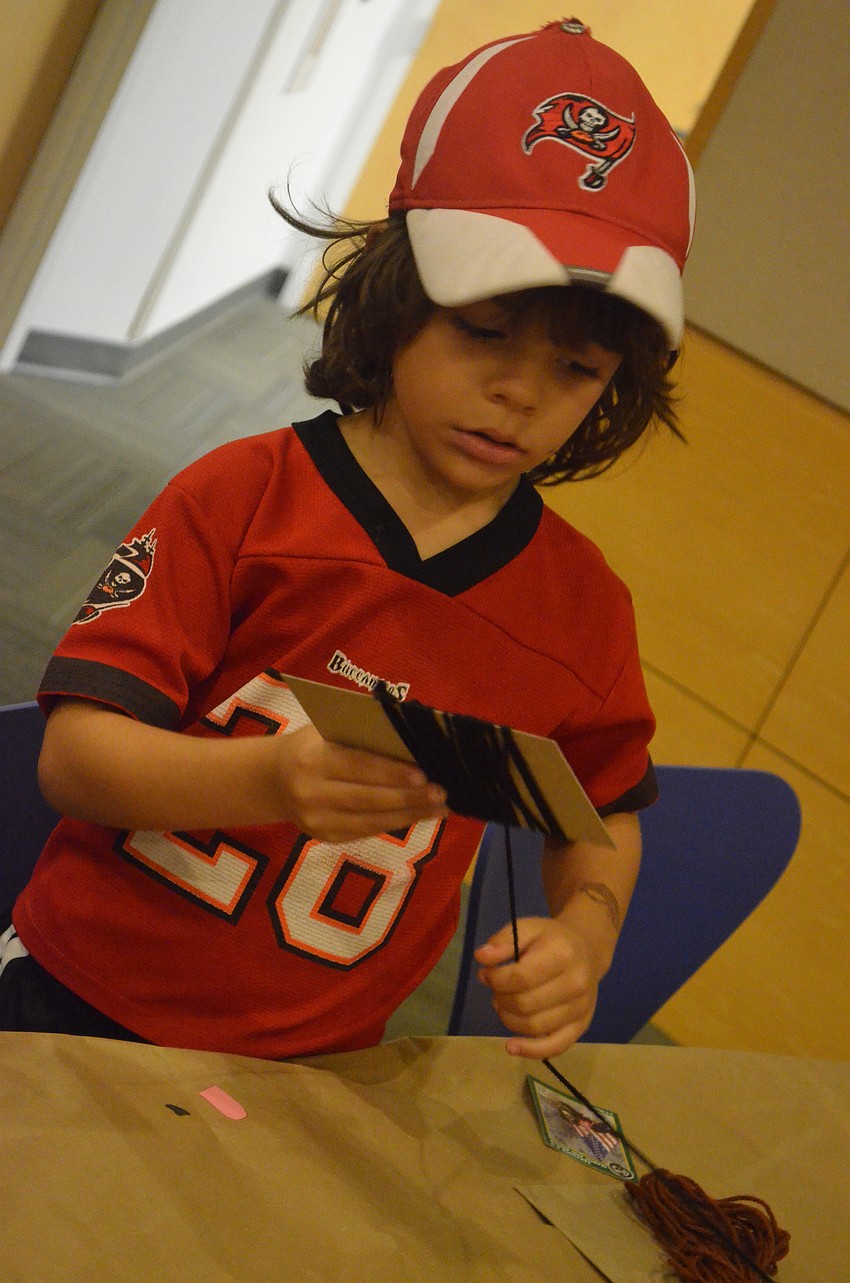 Lee Volpe, 6, makes a doggy yarn craft after the presentation.