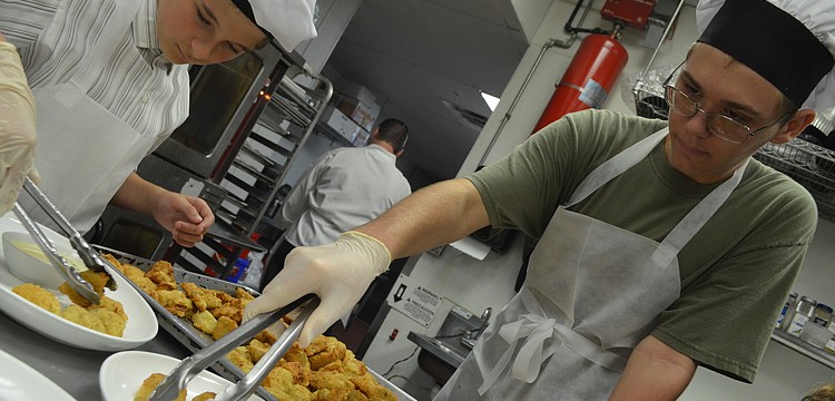 Nicolas Duverneuil, 13, and Max Aston, 15, put artichokes on plates and hand them to the servers to take out to the guests.