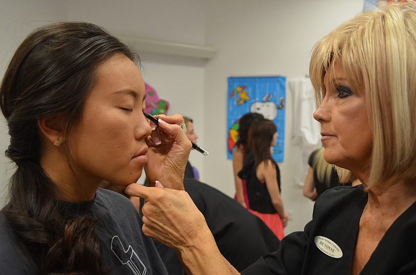 Merle Norman, of Merle Norman Cosmetics, volunteers and puts on make-up for model Jenny Dong.