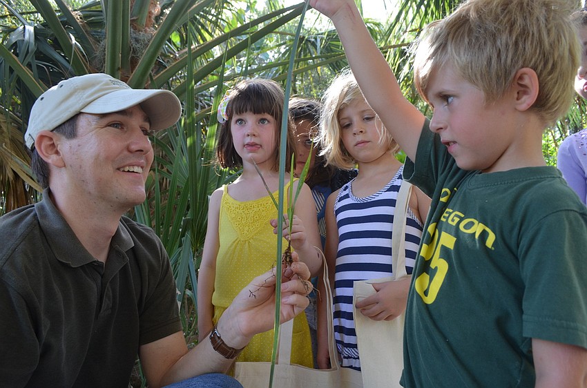 Land Stewart of the Conservation Foundation of the Gulf Coast Lee Amos teaches Claire Toale, 5, Chelsea McKay 5, and her brother Liam, 4, and other children about the plants and trees that grow around them.
