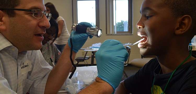 David Freeman of Freeman Orthodontists checks 11-year-old Milan Smithâ€™s teeth for cavities.  This is the third year Freeman has participated in Day of Hope.