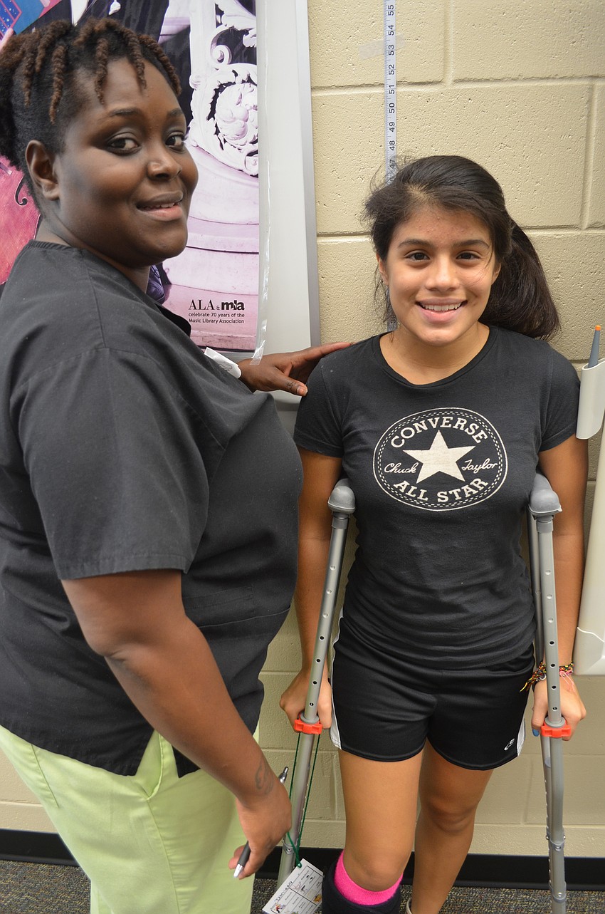 Sandra Edna of Sarasota memorial Hospital Emergency Room checks 16-year old Daniella Riveraâ€™s height.