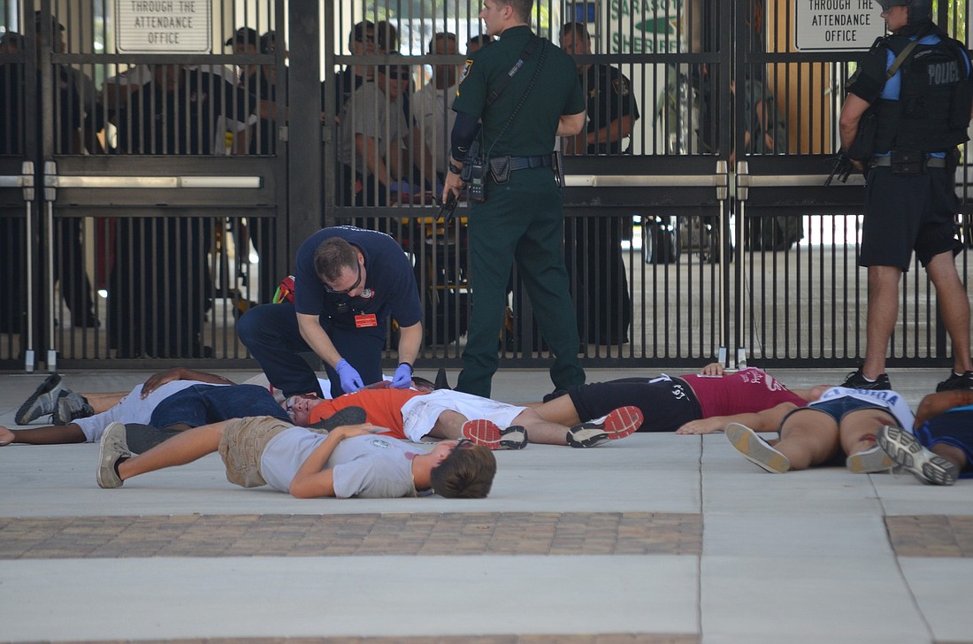 EMT personnel quickly took away actor victims at Riverview High School during the security exercise.