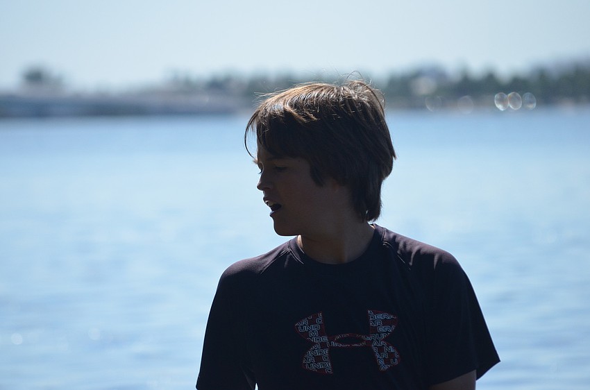 Jake Barrett, 12, talks to his partner Ben Gansle, 10, about their catch.