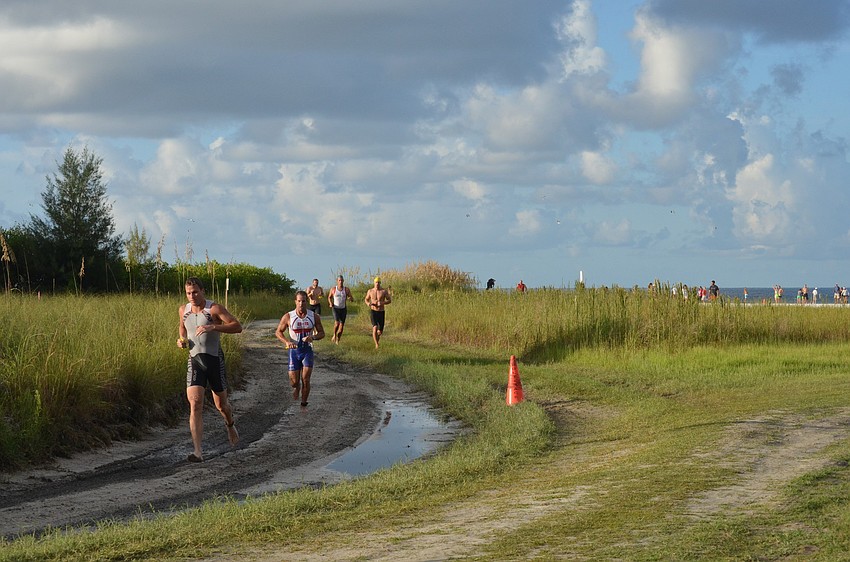 Triathletes race from their swim on Siesta Key Beach to mount their bikes at the Multirace Siesta Beach Olympic and Sprint Triathlon.