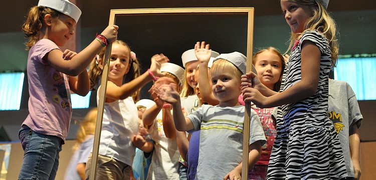 Children act out a living museum exhibit.