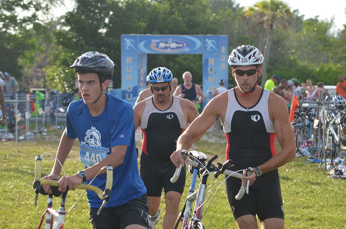 Athletes get ready to mount their bikes and take off during the transition of the Siesta Key triathlon this weekend.