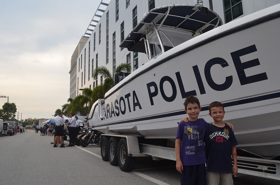 Ethan Knize and his brother, Liam, browse the booths of the Sarasota Police Department. Ethan tried on a SWAT team tactical vest and ballistic helmet.