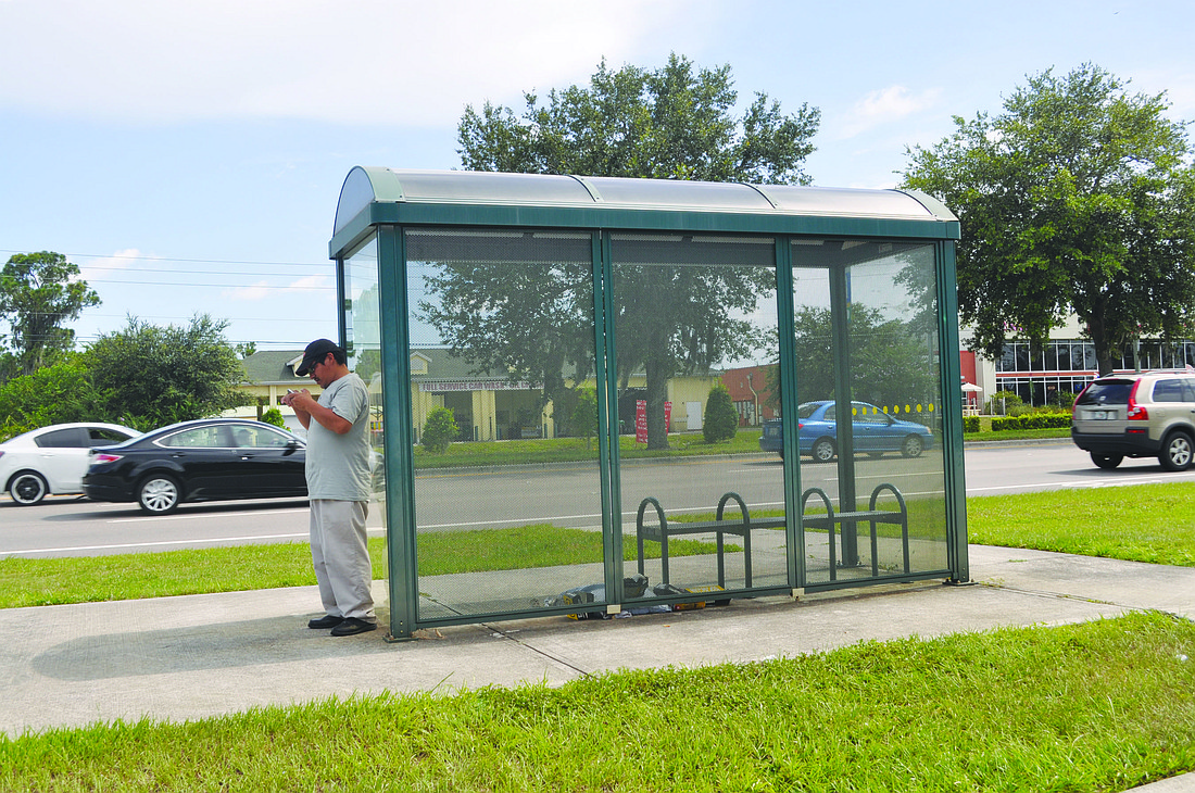 A man waits at a Sarasota County Area Transit bus on University Parkway. The Manatee County Area Transit service provides no buses on University Parkway east of U.S. 301.