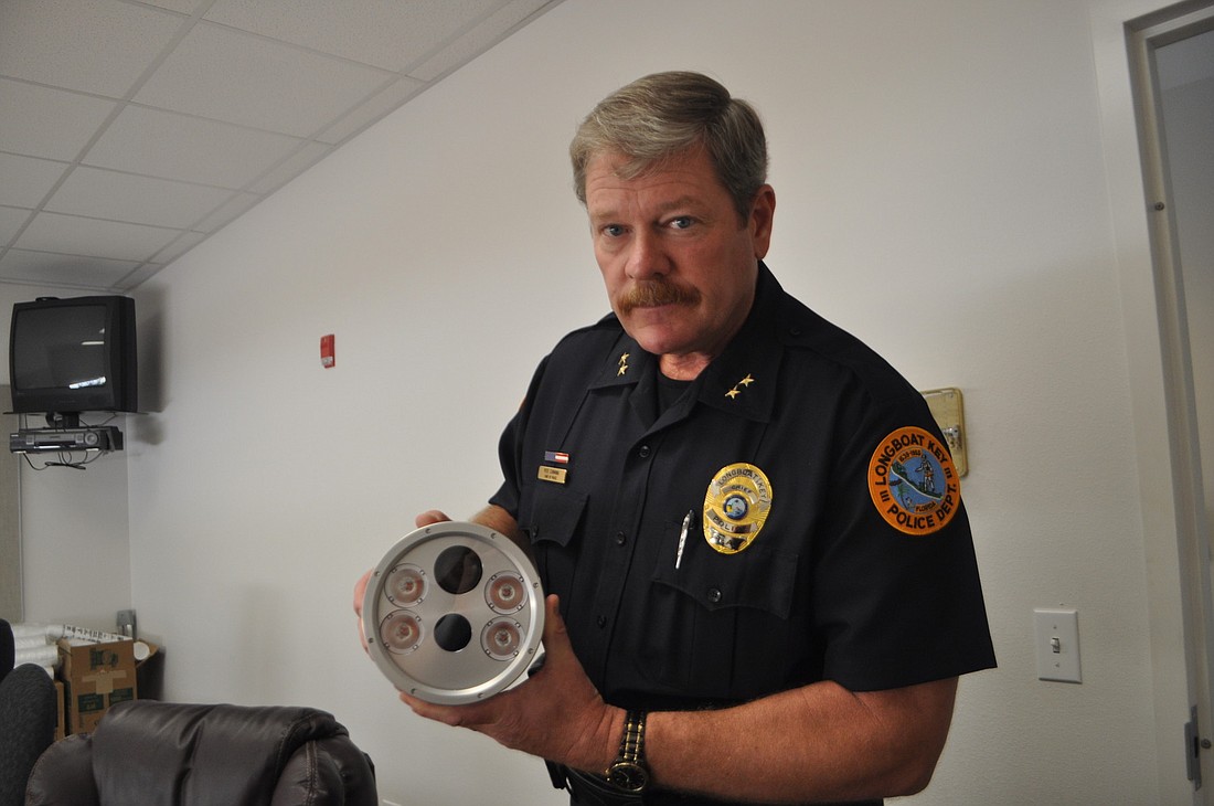 Longboat Key Police Chief Pete Cumming holds one of the six cameras that are now capturing data.