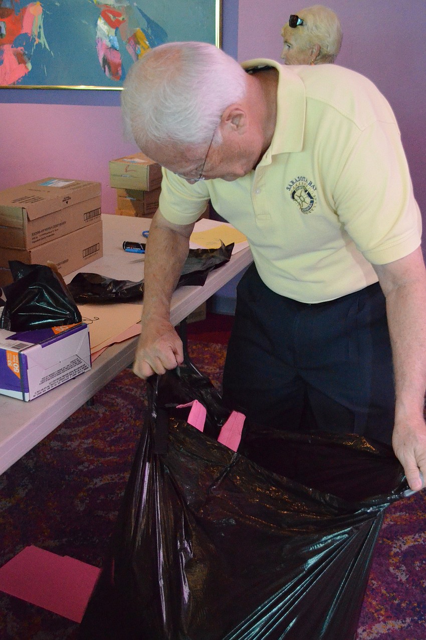 Mike Murphy places the filled backpacks into large bags for delivery.