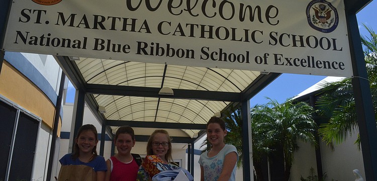 Katherine Lumpkin, 10, her sister Mallory, 8, Avery Blechta, 10, and her sister Grace, 11, bring supplies to St. Martha for the Back to School Bash.