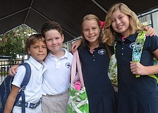 Second-graders Jackson F., and Blaine B., and fifth-graders Kaki F., and Dabney B., head back to school for their first day. They say hello to classmates after a summer away.