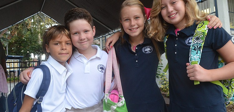 Second-graders Jackson F., and Blaine B., and fifth-graders Kaki F., and Dabney B., head back to school for their first day. They say hello to classmates after a summer away.