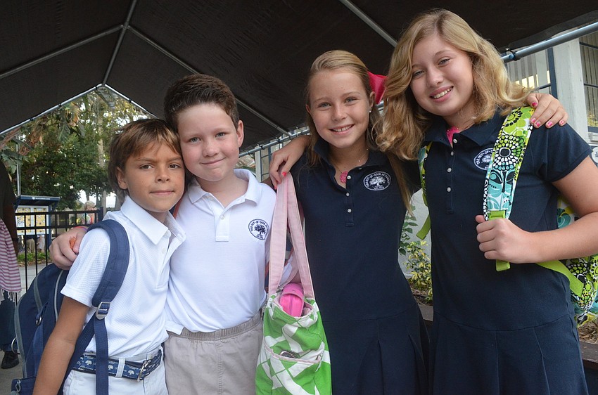 Second-graders Jackson F., and Blaine B., and fifth-graders Kaki F., and Dabney B., head back to school for their first day. They say hello to classmates after a summer away.