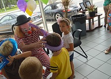 A clown made balloon hats for children.