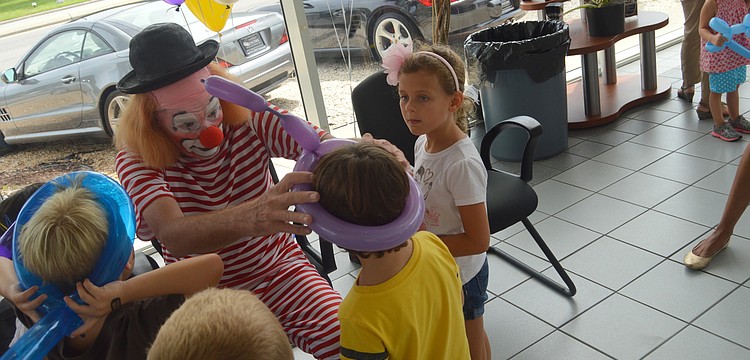 A clown made balloon hats for children.
