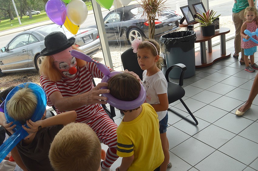 A clown made balloon hats for children.