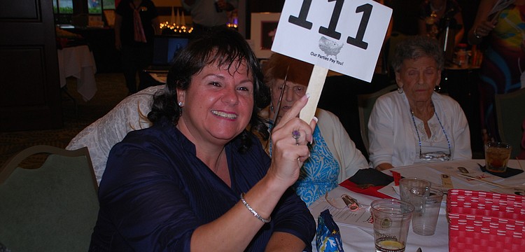 Christine Brudner takes part in the first auction of the night.