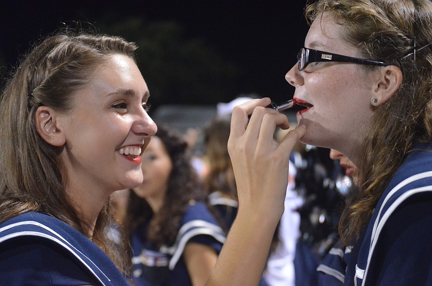 Senior Valorie Gochnauer touches up Lacey Landers' make-up during the game.