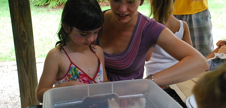 Justine Amdur and her daughter, Mia, partake in beading.
