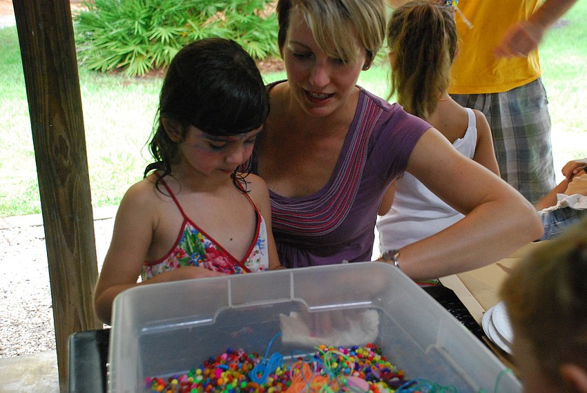 Justine Amdur and her daughter, Mia, partake in beading.