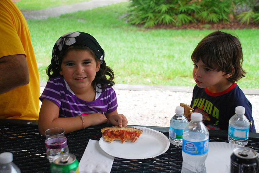 Simone Velez and Ezra Smith enjoy pizza while staying dry