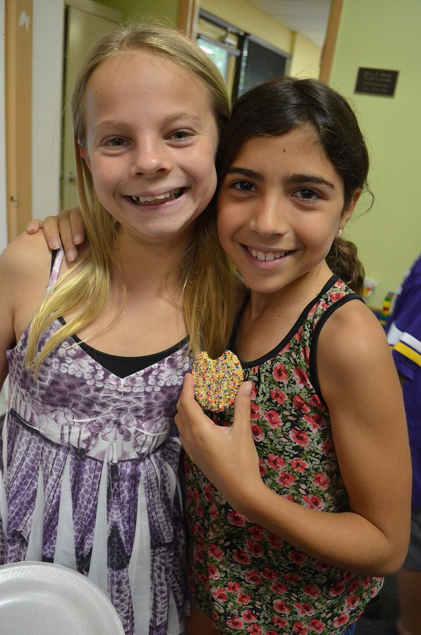 Katie Hurwitz, 10, and Catherine Cappelli, 10, munch on cookies and bagels with cream cheese at the Shmear and Shmooze event.