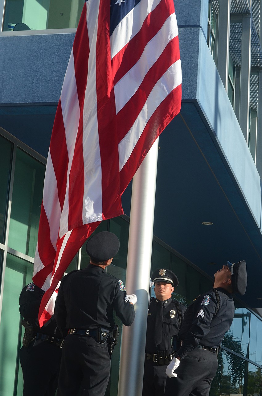 Sgt. Mark Opitz, Sgt. Rex Troche, Sgt. Mike Schwieterman and Officer Brian Singley raise the American flag during the ceremony.