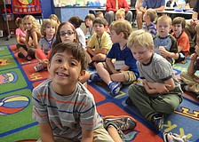Alex Wright listens to his kindergarten teacher, Susan Schaefer, call out attendance.