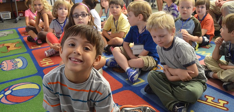 Alex Wright listens to his kindergarten teacher, Susan Schaefer, call out attendance.