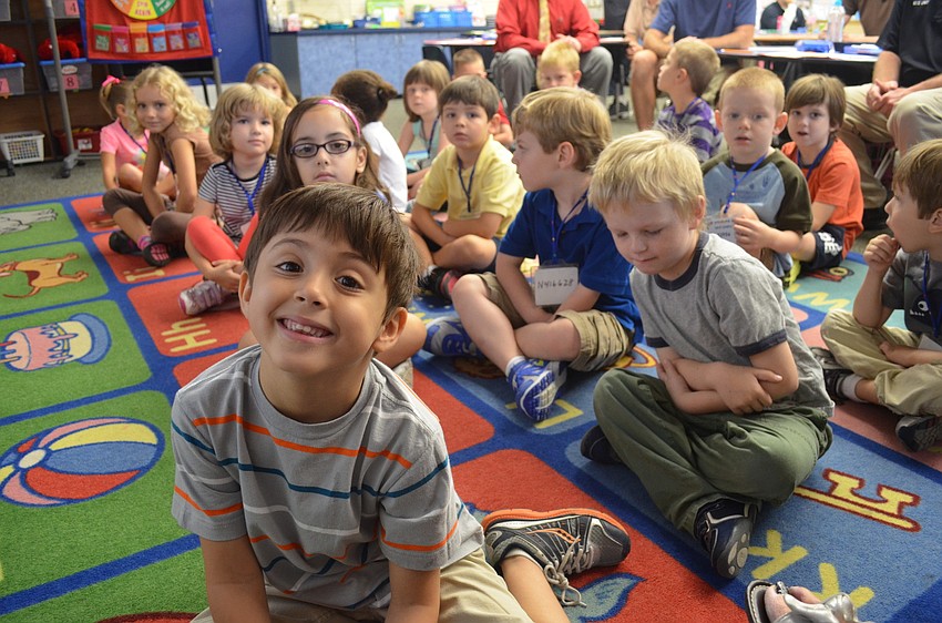 Alex Wright listens to his kindergarten teacher, Susan Schaefer, call out attendance.