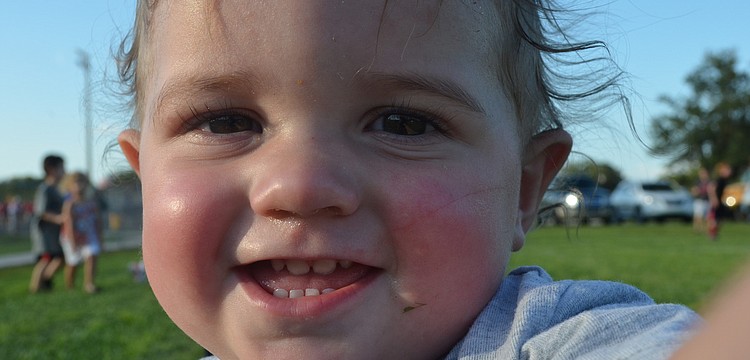 Declan Young, 13 months, plays in the grass during school spirit day.