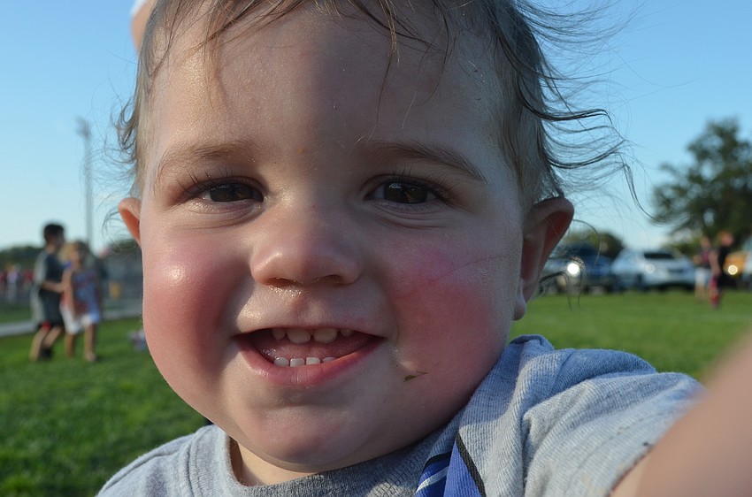 Declan Young, 13 months, plays in the grass during school spirit day.