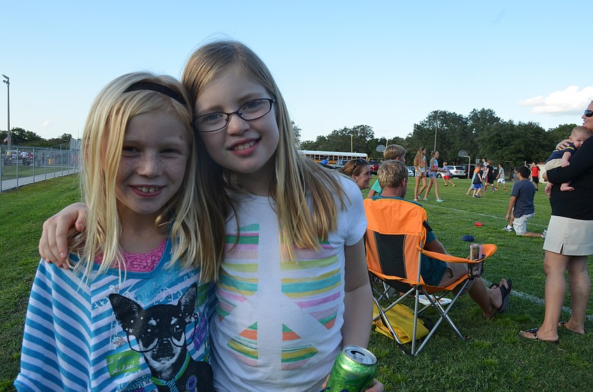 Kaitlyn Hornung, 9, and Emma Burd, 9, run around the field at the tailgate.