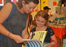 Vera Lombardi and daughter Kelly look through the books