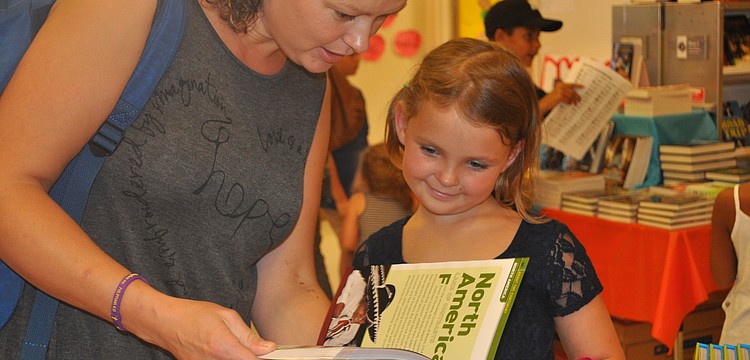 Vera Lombardi and daughter Kelly look through the books