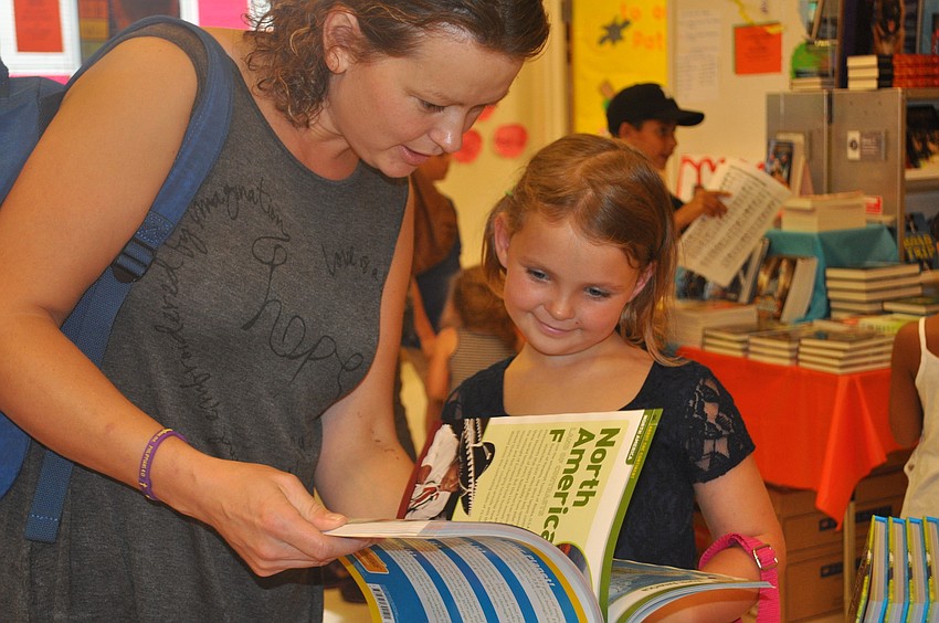 Vera Lombardi and daughter Kelly look through the books